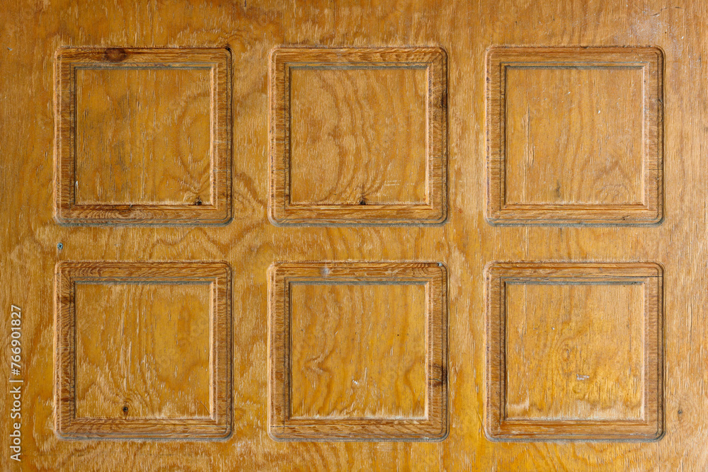 Obraz premium Brown plywood door texture with square decorative recessions carved into it