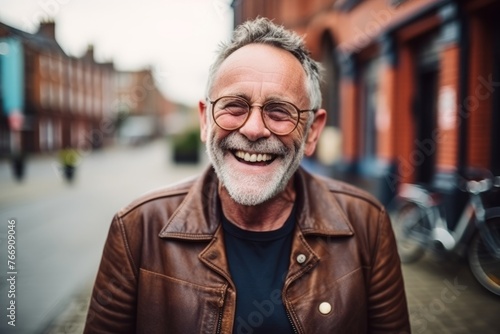 Portrait of a smiling senior man with glasses in a city street