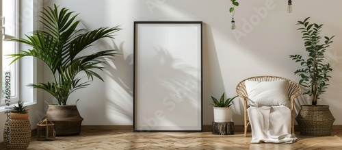 The 70x100 frame mockup poster is displayed in a corner of the living room on the wooden floor, leaning against a white wall adorned with plant decor. photo