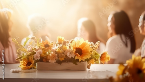 A group of women are sitting around a table with flowers in the center