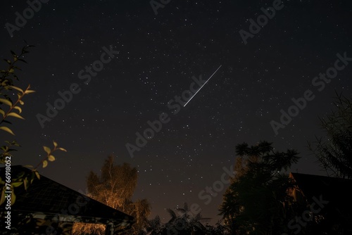 A shooting star streaks across the night sky  leaving a glowing trail behind it