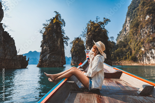 Traveler asian woman relax and travel on Thai longtail boat in Ratchaprapha Dam at Khao Sok National Park Surat Thani Thailand © Peera
