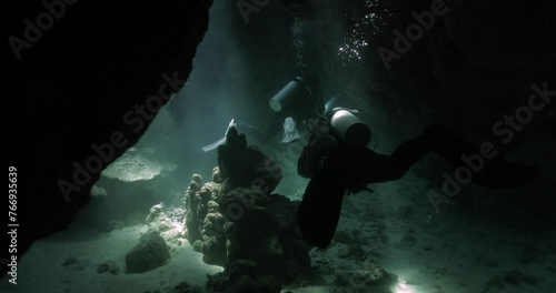 divers filming in a cavern deep in the redsea photo