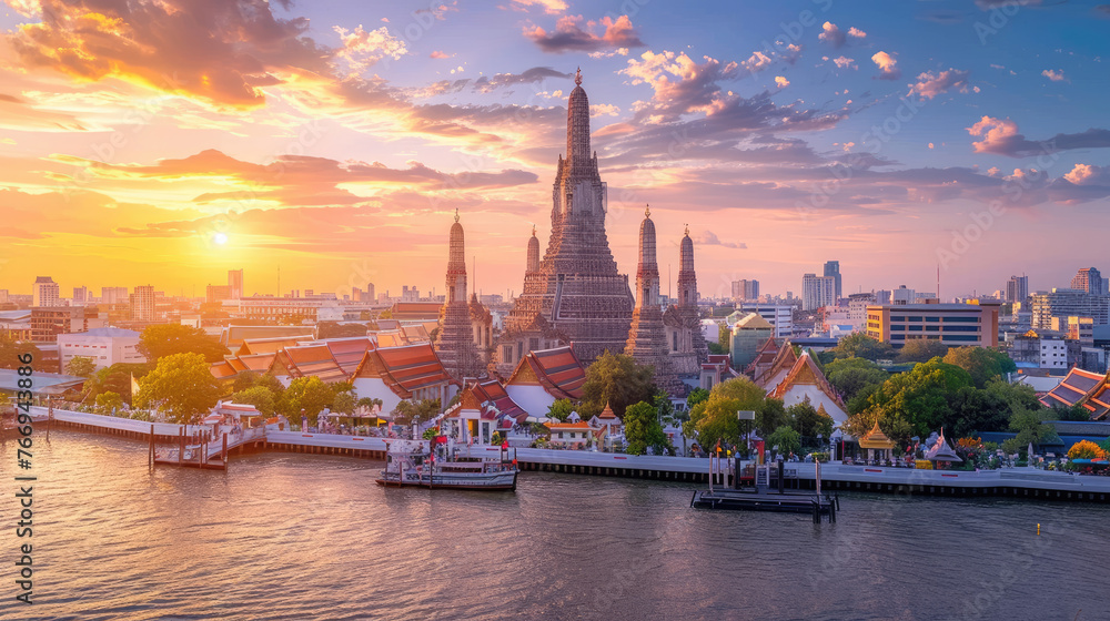 A panoramic view of Wat Arun temple at sunset in Bangkok, Thailand with the river and city in the background