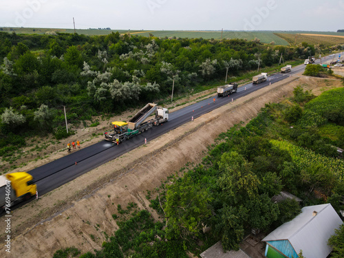 Chernivtsi, Ukraine-07.19.2021: Road equipment and road workers repairing the road photo