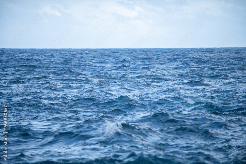 Calm sea water surface texture with splashes and waves. Abstract nature background. Background of aqua ocean water surface.