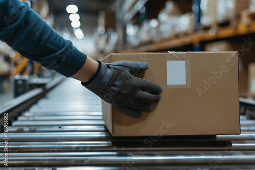 Worker handling a cardboard box on a conveyor belt