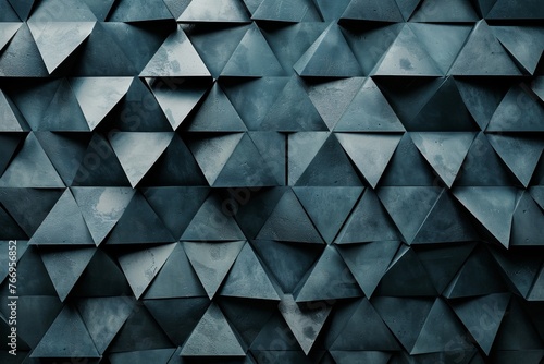 Dark gray wall made of triangular shapes, creating an abstract and modern background with geometric patterns