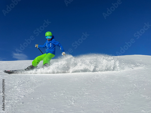 Kid have ski fun launch a flurry of snow into the air on slope