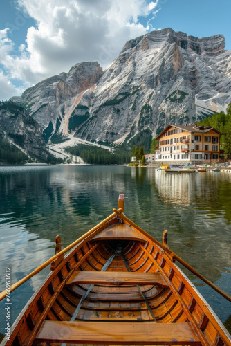 Serene Lakefront View with Wooden Boat and Majestic Mountain Backdrop