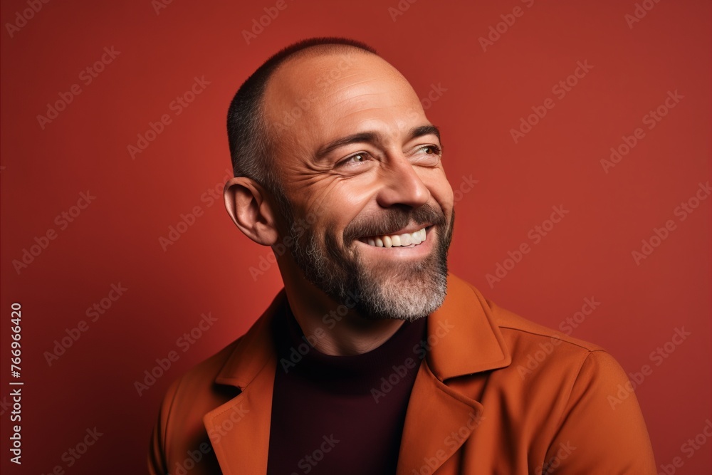 Portrait of a happy mature man in coat on red background. Portrait of a happy mature man in coat on red background.
