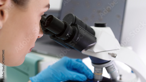 A scientist in a modern medical laboratory looks into a microscope. A doctor is a laboratory assistant in a modern laboratory with technological equipment.