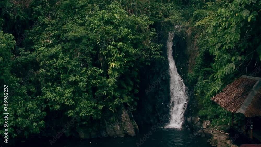 Ambient motion of cascading water among the green lush tropical jungle foliage in PulangBato Waterfalls, a popular tourist destination in Valencia, Negros Oriental Philippines Ambient motion of cascading water among the green lush tropical jungle foliage in PulangBato Waterfalls, a popular tourist destination in Valencia, Negros Oriental Philippines