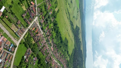 Vertical aerial video of Viscri Village. Situated in the center of Romania is a small village that has become famous travel destination. Drone going forward. photo