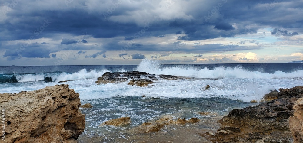 Waves crashing in the Mediterranean sea as storm approaches over the horizon