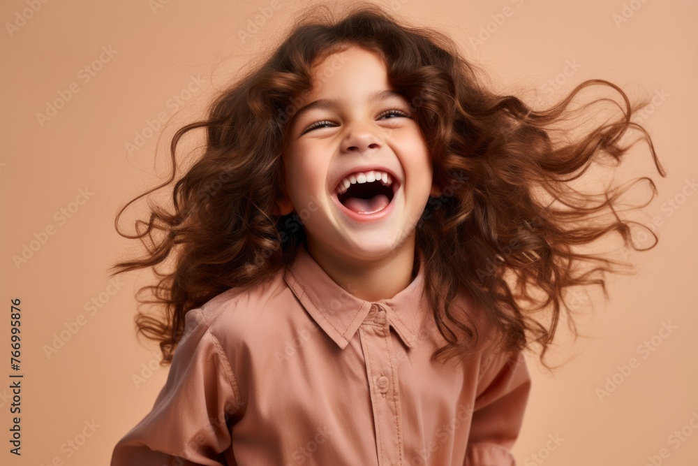Portrait of a cute little girl with flying hair on a brown background Portrait of a cute little girl with flying hair on a brown background