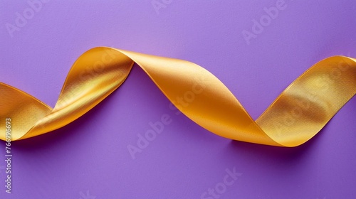 Golden ribbon isolated on purple background. Close-up. Copy space.