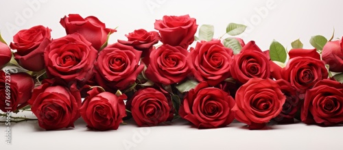 A beautiful arrangement of hybrid tea roses, garden roses, and artificial flowers in a bouquet on a white background