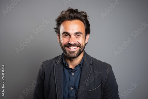 Portrait of a handsome young man smiling at the camera over grey background