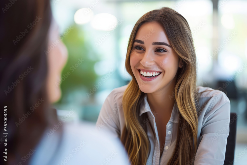 Smiling female manager conducting a job interview in a well-lit office Smiling female manager conducting a job interview in a well-lit office