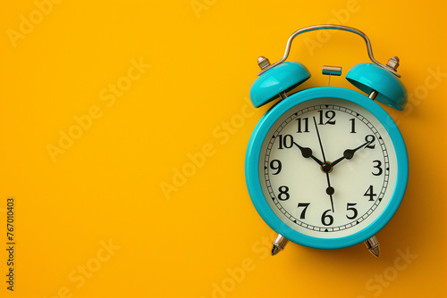 A blue clock face with an alarm set, on a yellow background with copy space