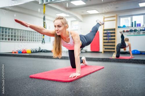 Young woman works out in the gym performing an exercise for strong body and health