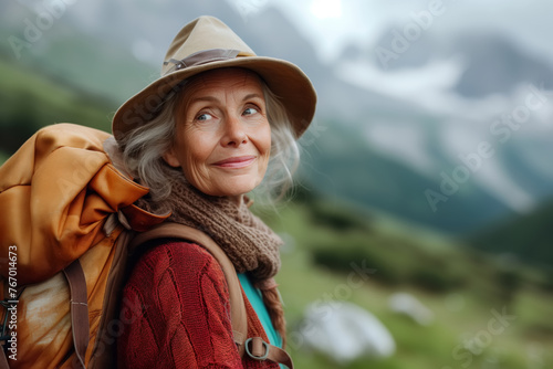 Retirement trip. Active elderly woman traveler traveling in the mountains in nature © Sergio
