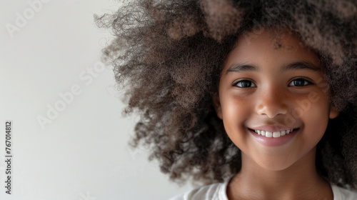 Smiling African American girl with afro hair on white. © Noreen
