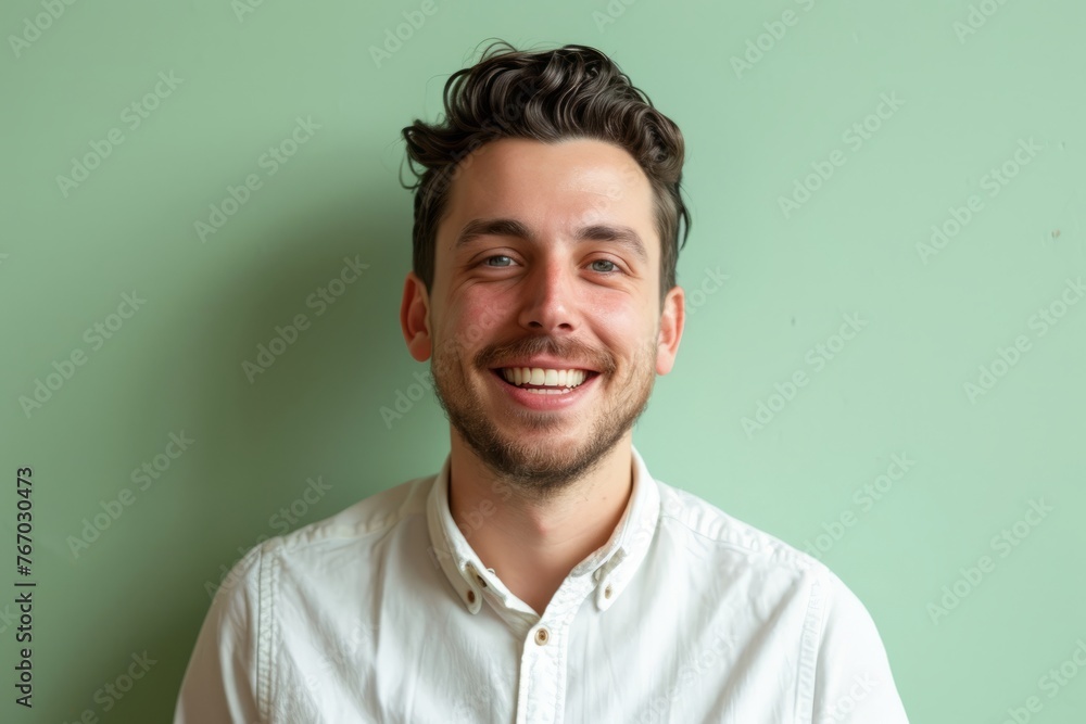 Portrait of a handsome young man smiling at camera against green background Portrait of a handsome young man smiling at camera against green background