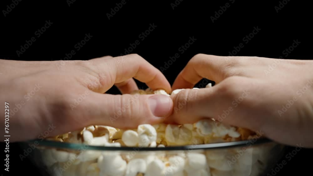 Two hands from both sides take a large handful of popcorn from the plate. Slow motion. Two hands from both sides take a large handful of popcorn from the plate. Slow motion.