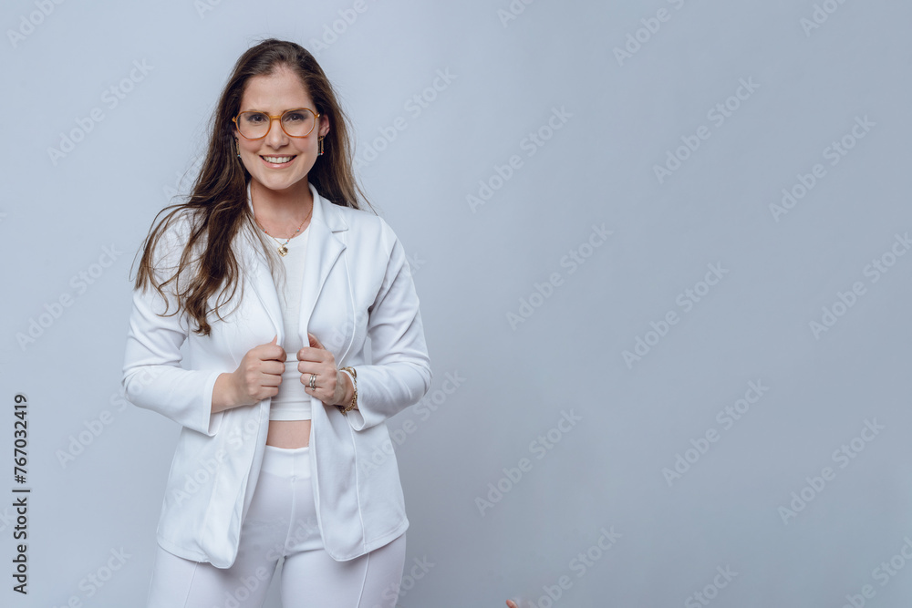 waist up portrait of young happy latin businesswoman in white elegant suit with glasses and long hair. waist up portrait of young happy latin businesswoman in white elegant suit with glasses and long hair.