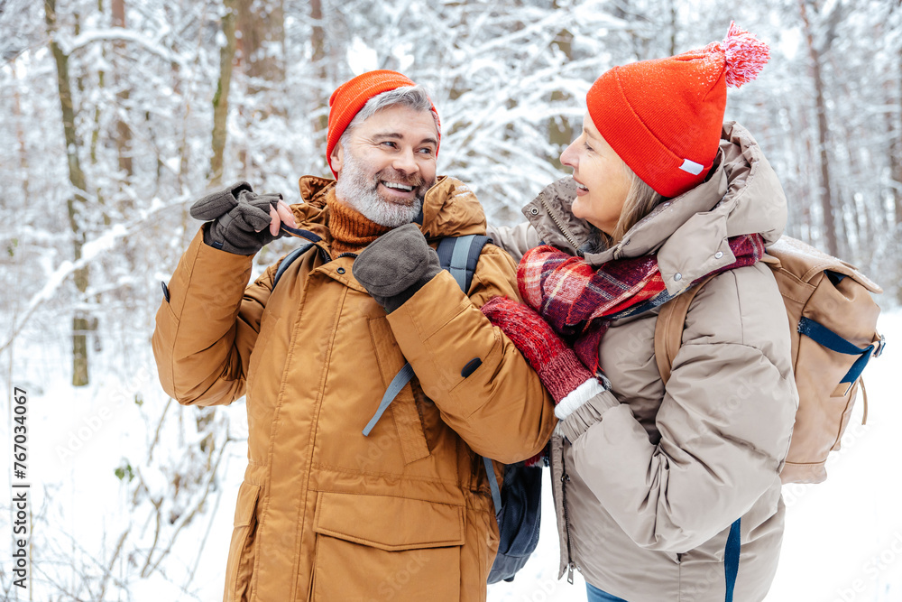 Mature couple in a winter forest feeling happy Mature couple in a winter forest feeling happy