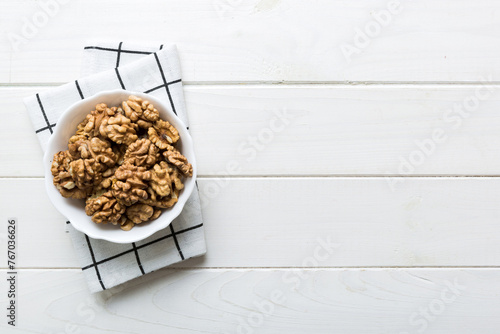 Fresh healthy walnuts in bowl on colored table background. Top view Healthy eating bertholletia concept. Super foods photo