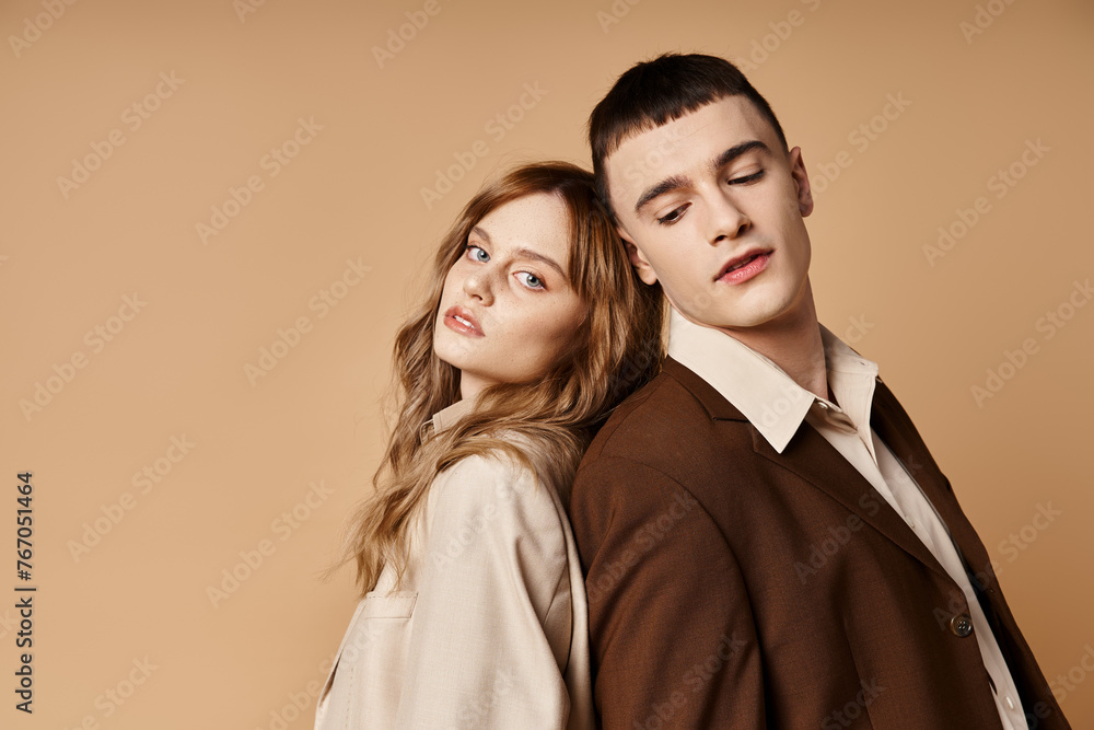 good looking man in debonair suit posing next to his beautiful girlfriend who looking at camera good looking man in debonair suit posing next to his beautiful girlfriend who looking at camera