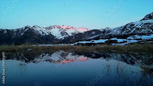 Sunset over the Pyrenees mountains with the reflection of the peaks in the water of the lake High quality 4k footage photo