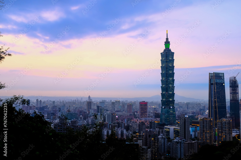Naklejka premium Aerial view of skyline of Taipei city with Taipei 101 Skyscraper at sunset from Xiangshan Elephant Mountain. Beautiful landscape and cityscape of Taipei downtown buildings and architecture in the city