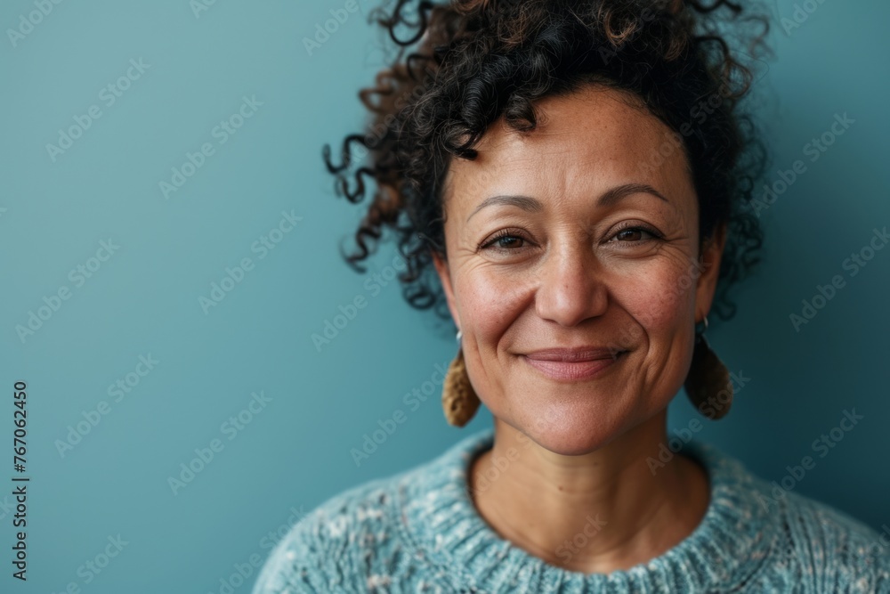 Portrait of a smiling woman with curly hair on a blue background Portrait of a smiling woman with curly hair on a blue background