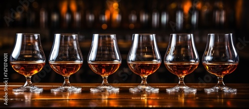 Four wine glasses of cognac are elegantly displayed on the bar, waiting to be savored by guests in need of a classy and sophisticated drink