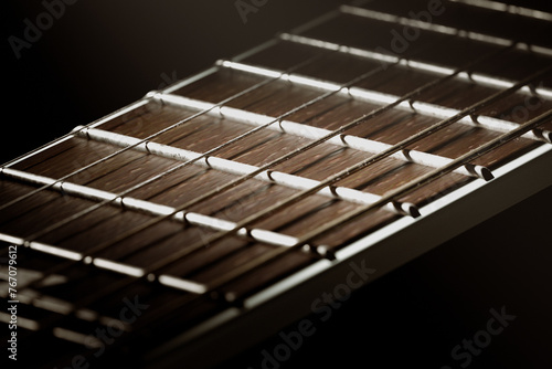 Exquisite Close-Up of Guitar Fretboard Against a Mysterious Dark Background