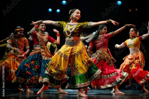 A diverse group of individuals are energetically dancing on a stage during a cultural performance