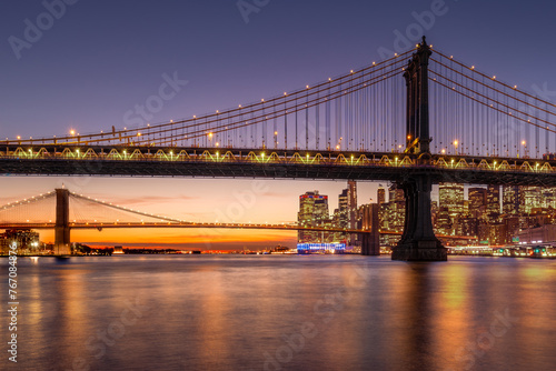 Manhattan Bridge and Brooklyn Bridge with East River and glowing sky sunset. Lower Manhattan skyline, New York City
