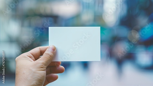 Photo of business cards stack. Template for branding identity. Isolated with clipping path. Hand holding white business card on blue blurred background