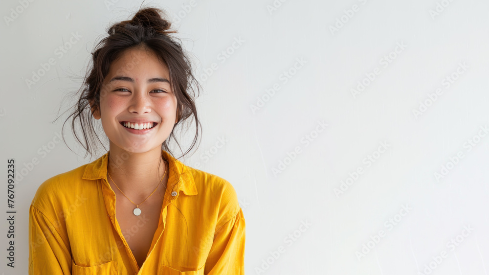 Asian woman wearing yellow shirt smiling laugh out loud isolated on grey Asian woman wearing yellow shirt smiling laugh out loud isolated on grey