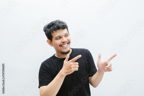 an asian man smiles and points to something with his hand photo