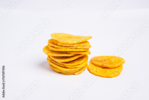 Green banana chips on white background