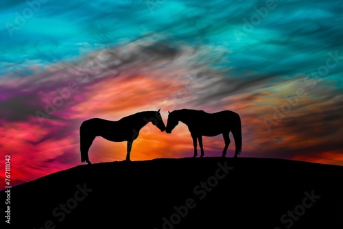 silhouettes of a horse couple against a vibrant sunset on a hill
