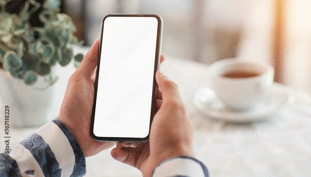 Mobile Phone for Mockup - Mobile Phone held by Hand at a desk or Cafe, at Home Environment - Template for Application Presentation Mobile Phone for Mockup - Mobile Phone held by Hand at a desk or Cafe, at Home Environment - Template for Application Presentation