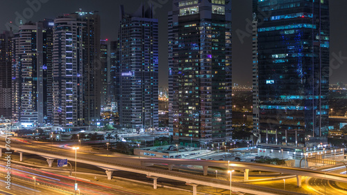 Aerial view of Jumeirah lakes towers skyscrapers night timelapse with traffic on sheikh zayed road.