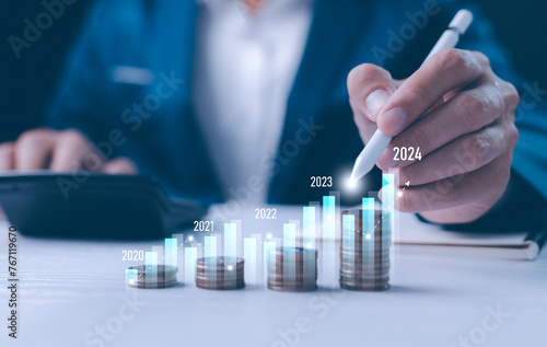 Obraz na płótnie Close-up businessperson analyzing a holographic financial chart. Conceptual image for financial analysis, forecasting, and digital economy. Growth of year, 2024, businessman calculates financial data. w salonie
