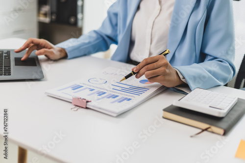 Businesswoman working with financial documents in the office is analyzing financial statistics and planning a budget. © Wasan